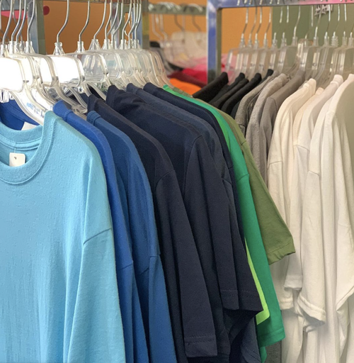 Racks of blank t-shirts and hoodies in many colors ready for decorating